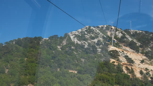 Travel on ropeway against green mountains