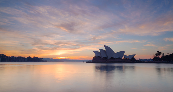 Sydney Australia - May 21, 2011: Early morning in Sydney, and the iconic Opera House and a glorious pre-dawn sky are reflected in the waters of Circular Quay.