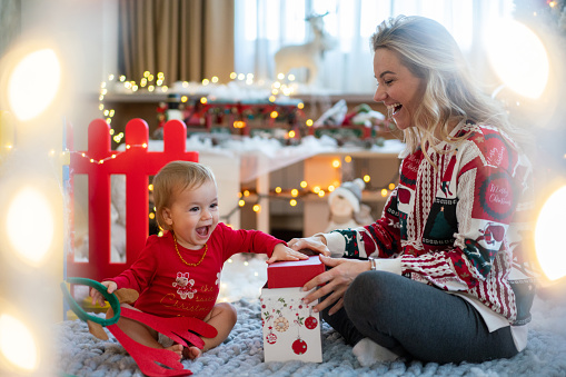 Happy mother and her daughter whit Christmas present at home