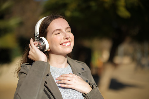 Happy woman walking feeling and listening to music