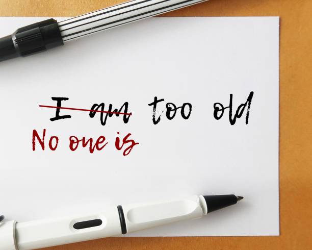Office envelope with pen and handwritten text I AM TOO OLD, changed to NO ONE IS TOO OLD, to transform negative self-perceptions of aging to positive one and keep set goal or dream to follow sobre de oficina con bolígrafo y texto escrito a mano soy demasiado viejo, cambiado a nadie es demasiado viejo, para transformar las autopercepciones negativas del envejecimiento en positivas y mantener una meta establecida o un sueño a seguir