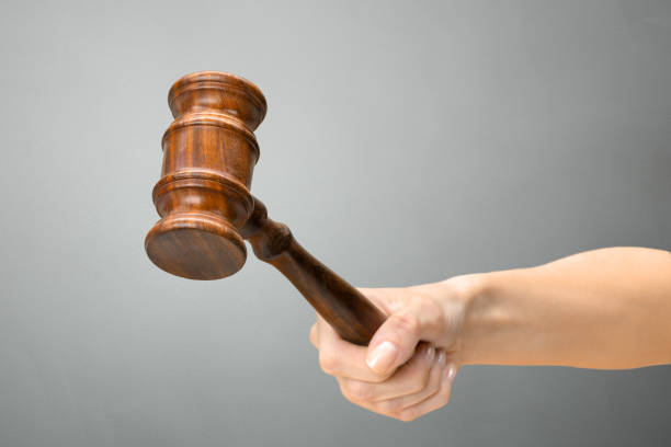 istock someones hand holding Wooden Law Gavel 1497809355