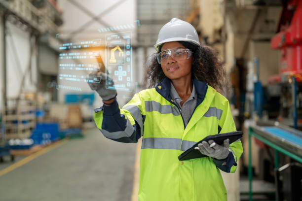 istock Systematical planning work increase production capacity and reduce costs. Production planning manager in reflective safety suit holding digital tablet and point to the futuristic digital graphic screen was shown the instruction to control robotic machine 1497809928