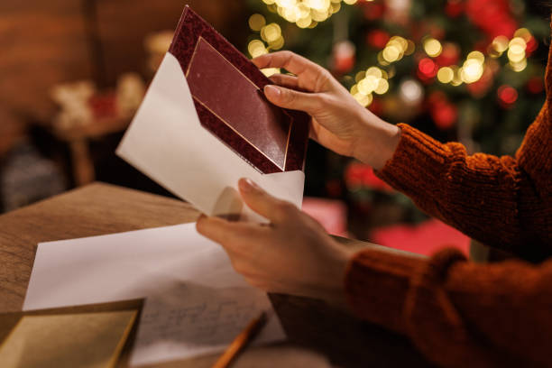Young woman putting a Christmas card in an envelope