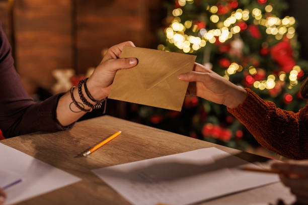 istock Young man giving his girlfriend an envelope with a Christmas card he wrote 1497813215