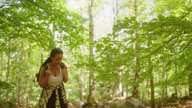 Woman with a backpack walking through a forest