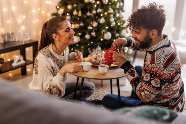 istock Young man pouring tea from a teacup for his girlfriend and himself 1497818082