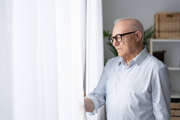 istock Sad serious mature man looking from window 1497818550