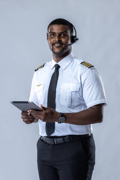 istock Smiling aircraft pilot. Professional Confident pilot expert. Handsome man wearing airplane pilot uniform. Aviators portrait on white background. Airline captain standing on white background 1497819966