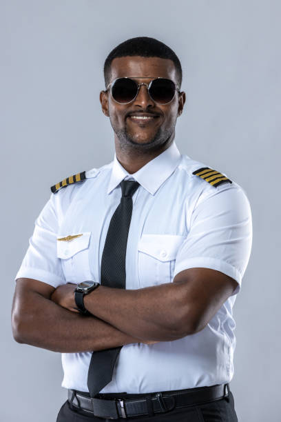 istock Smiling aircraft pilot. Professional Confident pilot expert. Handsome man wearing airplane pilot uniform. Aviators portrait on white background. Airline captain standing on white background 1497819969