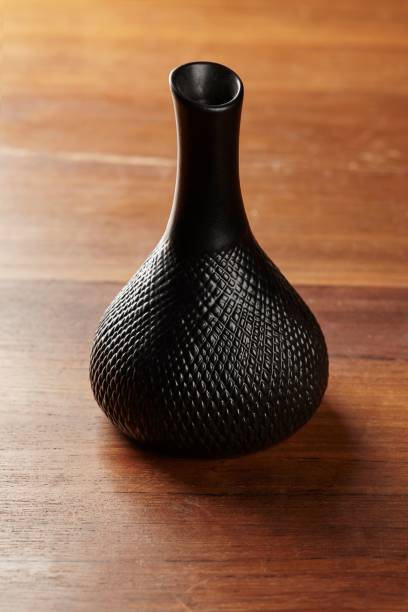 vertical shot of a unique black bottle on a wooden table