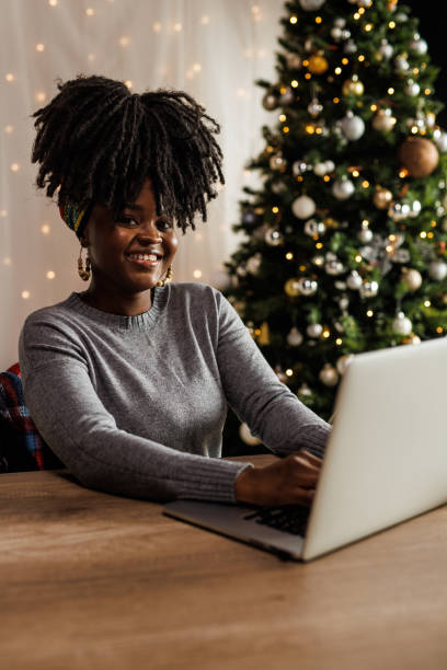 istock Young woman working from home office during Christmas holidays, typing data on laptop 1497825855