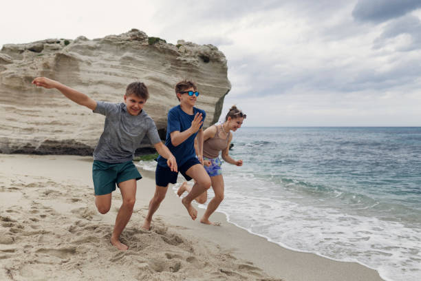 istock Happy teenagers running on the beach 1497825916