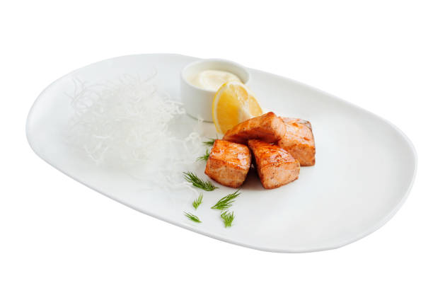 Grilled pieces of salmon on the white plate.