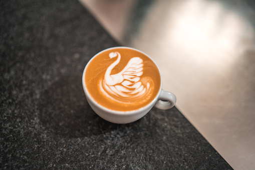 An eye-catching presentation of latte art on coffee cups, serving as a visual spectacle at the bustling cafeteria, enticing coffee enthusiasts with its captivating designs.
