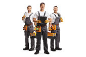 Team of electricians holding cables and team leader holding a clipboard
