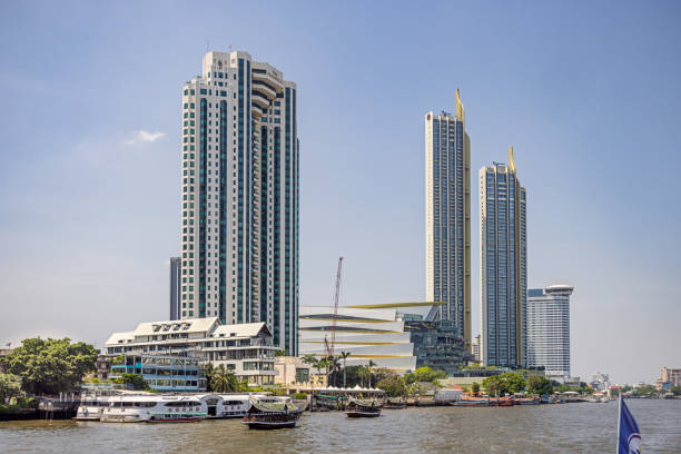 Chao Phraya River, Bangkok, Thailand - March 26th 2023: Modern high rise buildings at the brink of the river which runs through the capital of Thailand
