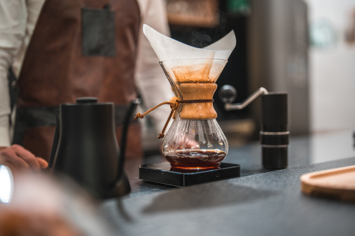 Experience the captivating sight of drip coffee being made on a coffee house counter, as the brewing process unfolds, showcasing the meticulous techniques and expertise employed to achieve a perfect pot of coffee, without any people in the frame.