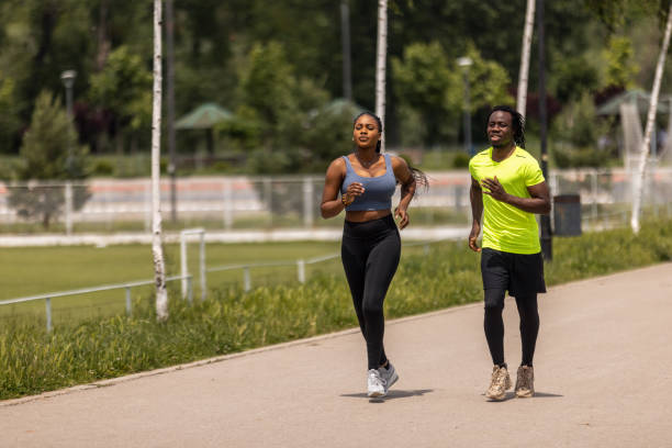istock Young couple running together in a public park 1497830456