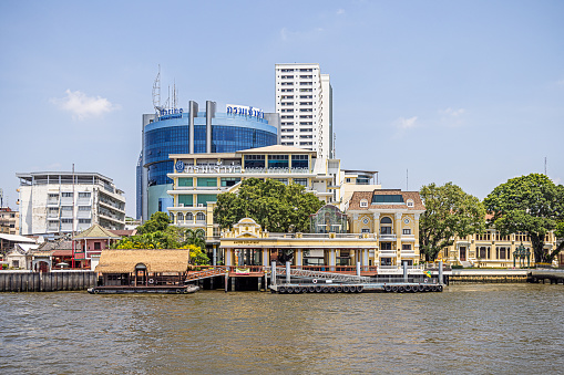 Chao Phraya River, Bangkok, Thailand - March 26th 2023: Modern high rise buildings at the brink of the river which runs through the capital of Thailand