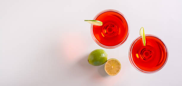 istock Alcoholic cosmopolitan cocktail in glasses and lime on the table top view web banner 1497830565