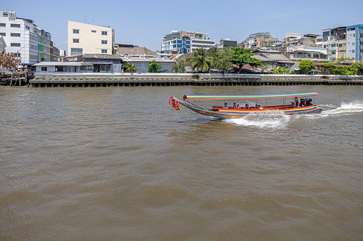 Chao Phraya River, Bangkok, Thailand - March 26th 2023: Longtail boat for passenger transport on the river which runs through the capital of Thailand