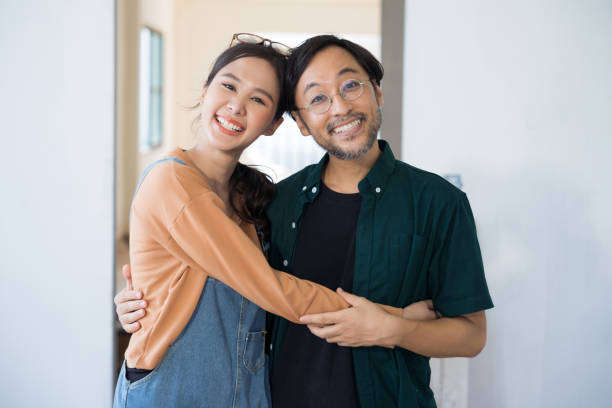 istock Portrait Asian couple looking at camera at home 1497832037