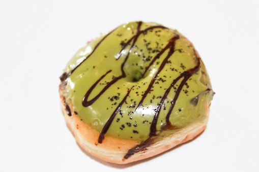 a donut with green tea and chocolate topping, on a white background