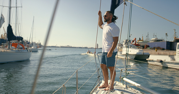 Man, yacht or boat trip at sea for vacation or holiday and travel for peace in nature. Male person on a sailboat to relax while sailing or cruise on ocean or water in summer