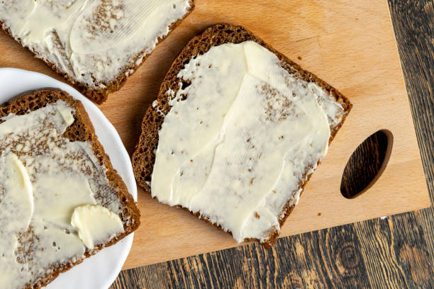 Black rye bread with butter Black rye bread with butter, cooking a simple and quick breakfast of bread and butter butter margarine isolated portion stock pictures, royalty-free photos & images