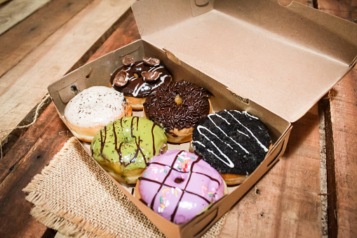 some donuts with a variety of toppings in the box, for dessert