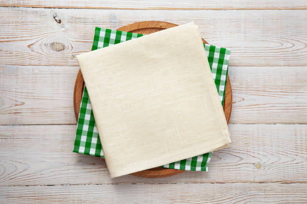 istock Empty pizza board and napkin on white wooden top view. 1497840280