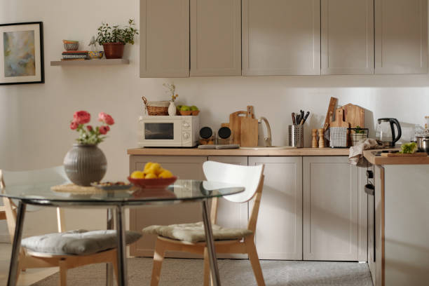 istock Part of spacious kitchen with glass round table and two wooden chairs 1497843122