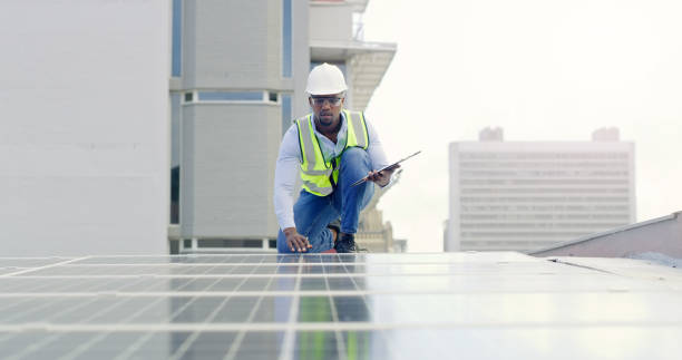 istock A young man writing notes while installing solar panels on the roof of a building 1497843169