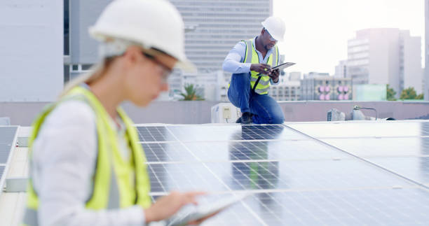 istock A young man writing notes while installing solar panels on the roof of a building 1497843172