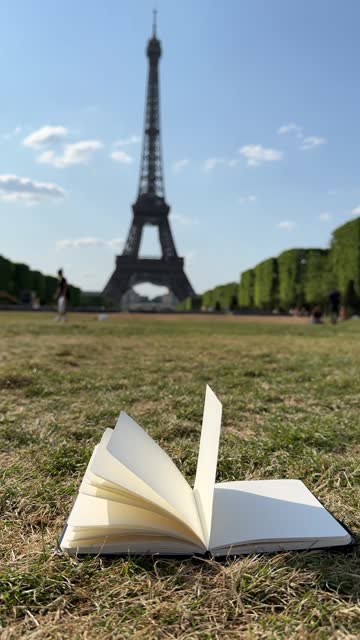 Wind Flipping Notebook Pages on Eiffel Tower background
