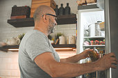 mature adult man taking food out of the fridge