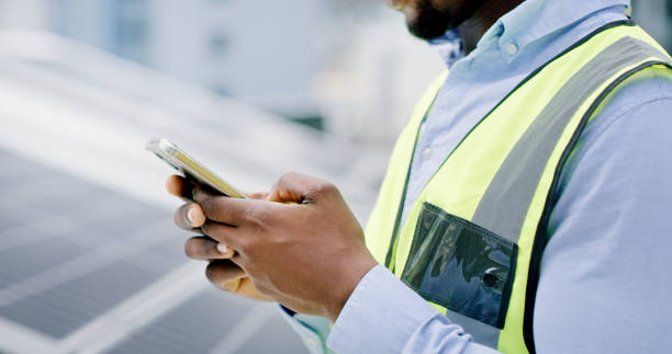 istock A man hands using a smartphone while installing solar panels on the roof of a building, Closeup of a construction worker working online with a phone on a renewable energy project 1497846746