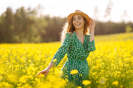 Beautiful woman in the blooming field. Nature, vacation, relax and lifestyle. Summer landscape.