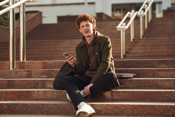 istock Young student with curly hair is outdoors near university 1497849459