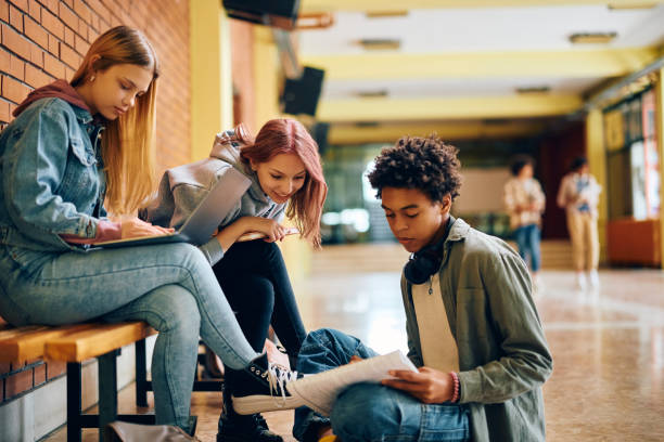 istock Group of high school classmates studying together in hallway at school. 1497850341