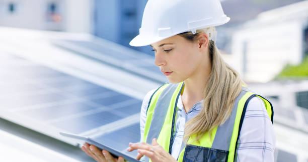 istock A young woman using a digital tablet while installing solar panels on the roof of a building. A construction worker working online on a renewable energy project 1497851680