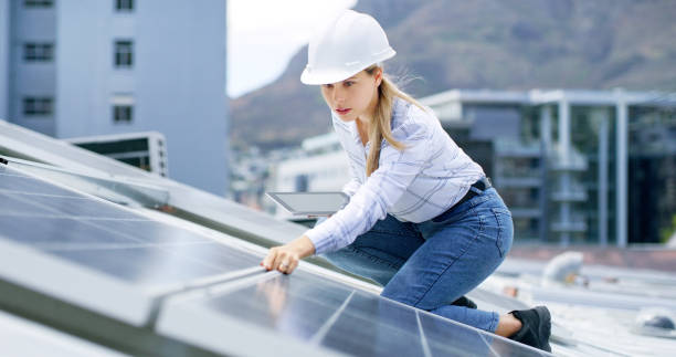 istock A young woman using a digital tablet while installing solar panels on the roof of a building. A construction worker working online on a renewable energy project 1497851697