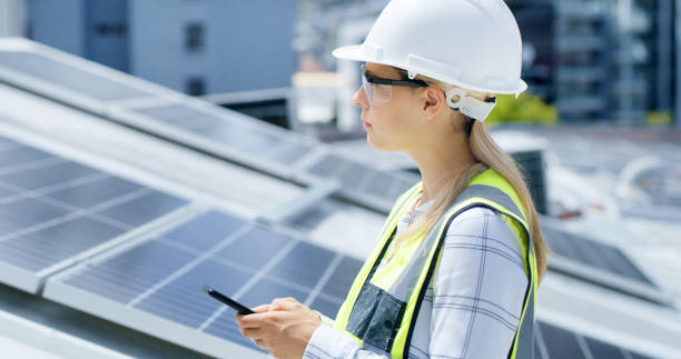 istock A serious young woman using a smartphone while installing solar panels on the roof of a building. A focused construction worker working online with her phone on a renewable energy project 1497851712
