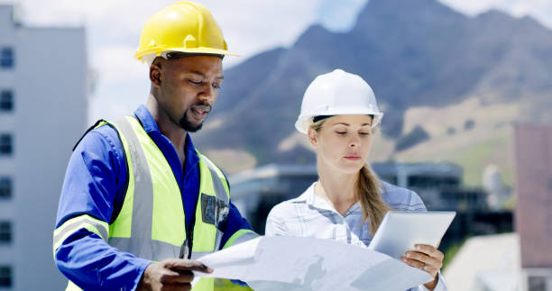 istock Engineers, architects and solar power technicians team with tablet or blueprint on building roof. Talking workers monitoring panels to harvest biodegradable energy source from sun 1497853038