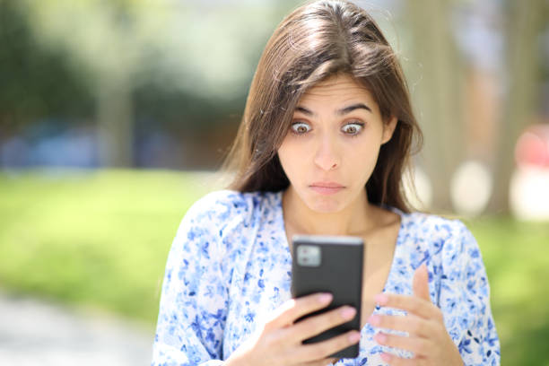 istock Perplexed woman checking phone in the street 1497854809
