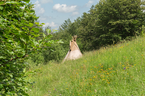 wigwam of beige color in a clearing in the Carpathian mountains, summer vacation, ethnic housing