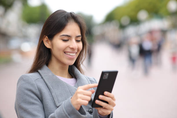 istock Woman using cell phone in street 1497855132