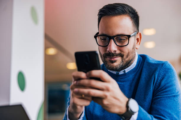 istock Close-up of a smiling man using a mobile phone, with glasses on. 1497857256