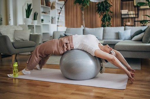 Senior woman exercising pilates at home